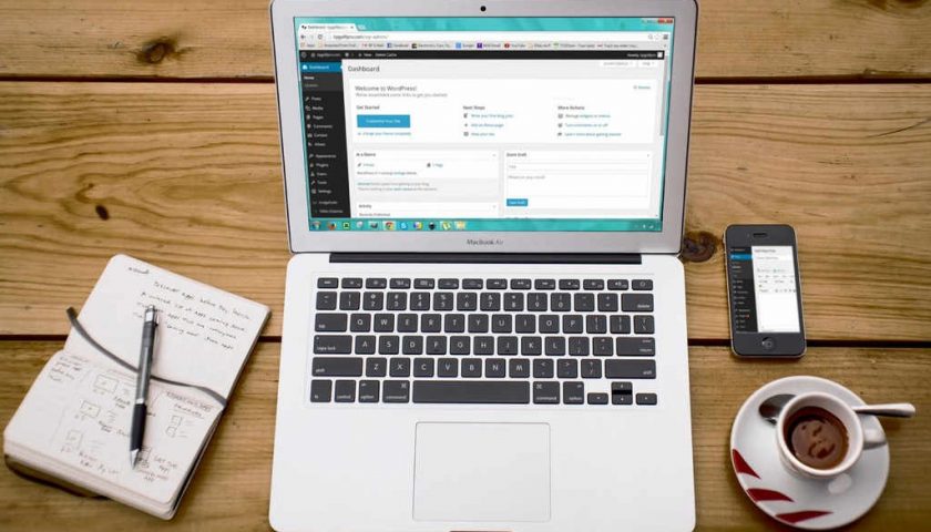 laptop on desk designing wordpress website