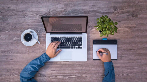 laptop on desk with coffee cup